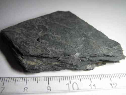 Pizarra arcillosa
Virginia, Estados Unidos
7x5 cm.
La diferencia entre esta roca y la anterior es que el metamorfismo incipiente ha provocado una mayor compactación, una foliación más definida y un ligero crecimiento del tamaño del grano. (Autor: prcantos)