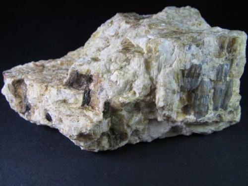 Pegmatita
Mina Nibbio mine, Mergozzo, Verbano-Cusio-Ossola Province, Piedmont, Italia
10 x 5 cm.
Pegmatita de feldespato con los accesorios: un zircón (pequeño y oscuro, abajo a la izquierda) y sillimanita azulada (a la derecha, cristales verticales). (Autor: prcantos)