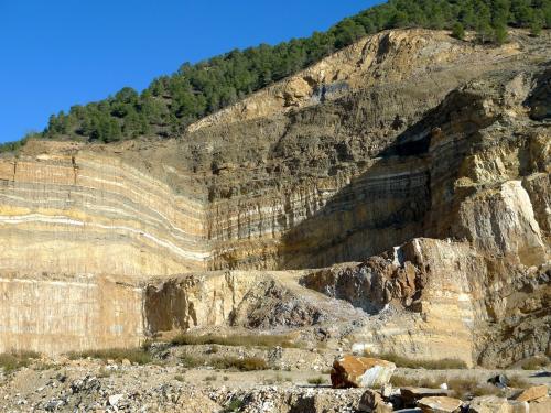 Dentro del Complejo Nevado-Filábride se encuentra la Formación Las Casas, que contiene tramos de micaesquistos, cuarcitas y rocas carbonatadas. Todo ello con un grado de metamorfismo medio.
Algunos niveles de los mármoles alcanzan un contenido en carbonatos superior al 95% y son los que se explotan en las canteras. Las coloraciones amarillentas se deben al hierro y las grises a materia orgánica. Algunos tramos mantienen un blanco impoluto. (Autor: Josele)