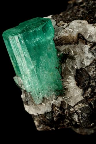 Beryl (variety emerald), Calcite, Parisite, Aragonite(?)<br />Muzo mining district, Western Emerald Belt, Boyacá Department, Colombia<br />38x40x31mm, xl=15x10mm<br /> (Author: Fiebre Verde)