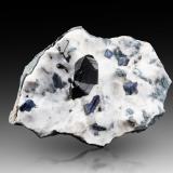 Neptunite (twinned) with Benitoite on Natrolite<br />California State Gem Mine (Benitoite Gem Mine), San Benito River headwaters area, Santa Rita Peak, New Idria District, San Benito County, California, USA<br />8.5 x 6.5 x 3 cm / main crystal: 2.4 cm<br /> (Author: MIM Museum)