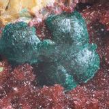 Fig. 19. Agregados esféricos de tirolita asociados a eritrina-annabergita creciendo sobre cristales de dolomita. C.V. 10 mm. Mina Los Picayos. Niserias. Peñamellera Alta. Asturias. Colección y foto Manuel Echevarría. (Autor: Echevarria)