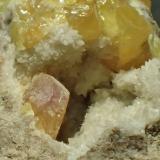 Azufre, calcitaMinas de Azufre, La Serrata, Lorca, Comarca Alto Guadalentín, Región de Murcia (Murcia), España0,7 x 0,4 cm (cristal anaranjado) (Autor: Frederic Varela)