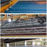 INSIDE THE ELECTROWINNING PLANT

The top photo shows the electrolytic cells during insertion of cathode plates. The middle photo shows the Copper clad cathode plates being removed from the tank for processing, and the bottom photo shows the tank charged with new blank cathode plates.

The plant included the use of permanent stainless steel cathodes. Unlike older methods that required “starter sheets” of Copper, these permanent cathodes reduced labor and operational complexities. The Copper was deposited directly onto these blanks, and then mechanically stripped off as high-purity cathode sheets. 

Outokumpu’s cell designs incorporated polymer concrete cells, known for their durability and chemical resistance in the acidic electrolyte environment. A double-contact bus bar system was a characteristic feature, ensuring efficient current distribution and minimizing energy losses. Ventilation hoods were fitted for effective mist control to capture sulphuric acid mist generated during electrolysis to improve worker safety and reduce environmental emissions.

Furthermore, the plant used advanced automation for handling and stripping the Copper cathodes. This included automated cathode pulling cranes that lift the entire cell hoods and then the loaded cathodes for washing and stripping. The emphasis was on maintaining precise control over electrolyte flow, temperature, and current density to optimize Copper deposition, achieve LME (London Metal Exchange) Grade A purity, and prevent issues like dendrite formation.

The rapid expansion to 65,000 tons of Copper cathode by 2008 further underscored the plant’s success and the efficiency of its design and operations. This increased capacity demonstrated the flexibility and scalability inherent in the SX-EW process, allowing for quick responses to market demands and maximizing the economic potential of the Milpillas ore body. The partnership between Outokumpu Technology, with its deep expertise in metallurgical solutions, and Industrias Peñoles, a significant player in the Mexican mining landscape, was crucial. This collaboration brought together world-class engineering and local operational knowledge, creating a facility that not only met but exceeded expectations. The Milpillas plant truly epitomizes the advancements in sustainable and efficient Copper production that defined the early 21st century.

Original photos courtesy of Ofelia Noyola (Author: silvia)