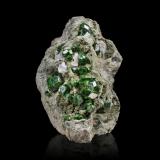Andradite (variety demantoid) with CalciteMontes Belqeys, Takab, Provincia Azerbaiyán Occidental, Irán12 x 13 x 14.5 cm / main crystal: 3.3 cm (Author: MIM Museum)