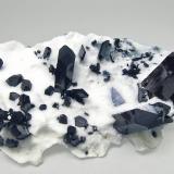 Neptunite and Benitoite on NatroliteMina California State Gem (Benitoite Gem Mine), zona cabecera Río San Benito, Pico Santa Rita, Distrito New Idria, Condado San Benito, California, USA6.4 × 3.6 × 2.1 cm (Author: Jordi Fabre)