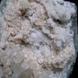 Dolomite and Calcite on QuartzZona de construcción de embalses, Condado Monroe, Indiana, USA15 cm x 10 cm, the largest calcites are about 2 cm (Author: Bob Harman)