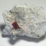 Red Beryl. Utah.  Beryl is gemmy with lots of cutting windows -- if one could even contemplate such a thing.  10.8 x 7.8 x 4.2 cm overall.  1.6 x 1.2 x 1.2 cm crystal. (Author: GneissWare)