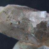 Phenakite on smoky quartz, Smoky quartz 6 x 2.5 mm  Phenakite crystal about 1 mm Mt Antero Colorado. (Author: nurbo)