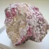 Picropharmacolithe needles with red erythrite, white guerinite crystals and some weilite (white crusts) from the Wechselshaft, Richelsdorf, Hesse. The sample measures about 7 cm in width. (Author: Andreas Gerstenberg)