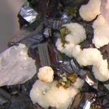 Tiny clusters of pyrite(?) ~4mm with 1mm cubes of pyrite nestled in an Aragonite bud (Author: Gordian)