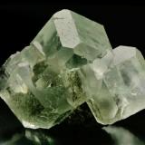 Fluorita, de delicada tonalidad verde, procedente de la zona minera de Xianghualing-Xianghuapu, en cuyos cristales   se observan claramente las formas {100} cubo y  {110} Rombododecaedro, característicos también de yacimientos asturianos tan significativos como los de la Collada, Arista del cubo 5 cm.
Foto: J. R. García (Autor: JRG)