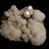 Analcime + chabazite + stilbite
Moonen Bay, Isle of Skye, Scotland, UK
Crystals to 13 mm

Analcime crystals to 13mm on matrix with pink chabazite and stilbite. Self-collected 1997 from Moonen Bay, Isle of Skye, Scotland. (Author: Mike Wood)
