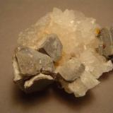 Same specimen, from the side.  Note that the galena cube has undergone expansion when it altered to anglesite and cerussite. I like these expanded galena cubes, in part because they are the opposite of exfoliation, the weathering process that produces rounded boulders.  Microcrystalline cerussite makes the ex-galena surfaces glitter.  Gift of Dr. Peter Megaw (Author: Ed Huskinson)