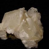 Calcite + stilbite. Basically a rhombohedral habit of transparent calcite, but elongated, into thin crystals, on a bed of stilbite. Specimen measures 55mm wide x 40mm high x 30mm deep. Self-collected 1994 from Sgurr nam Boc, Minginish, Isle of Skye. (Author: Mike Wood)