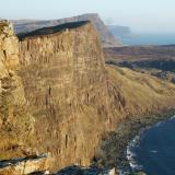 Cliff-top above Oisgill Bay, Isle of Skye. March 2007.Tertiary basalt lava flows are easily seen in the 600’ (200m) vertical sea-cliff. The even bigger cliff-top in the middle distance is called Waterstein Head (nearly 1000’ high or 270m) and tucked in behind it is Moonen Bay. (Author: Mike Wood)