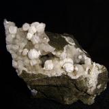 Gyrolite on Thomsonite
Moonen Bay, Isle of Skye, Scotland, UK
9 cm x 4 cm x 6 cm high

Some of the gyrolite shows alteration to a white powdery mineral. Self-collected from Moonen Bay in 1996. (Author: Mike Wood)