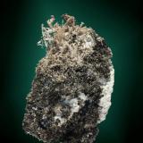 Plata
Falset, Priorat, Tarragona, Cataluña, España. Balcoll (m).(pozo no.2).
Agregado de cristales elongados y ganchudos, con acantita, icluidos en matriz de calcita (ejemplar de 2006).
5,5 x 4,0 x 3,5 cm. (Autor: Carles Curto)