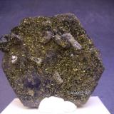 Epidota
Raywoo Mine, Quetta, Balochistán, Pakistán
6,5 x 6 x 2,5 cm
Esta pieza es de las de hábito tabular con pequeños cristales también tabulares o pseudo-octaédricos. Magnetismo moderado a fuerte. La única explicación cristalográfica que he leído proviene de unas piezas de Fabre Minerals en la página de Mindat de la localidad donde se describen como cristales con un pinacoide frontal muy desarrollado. (Autor: Antonio Alcaide)