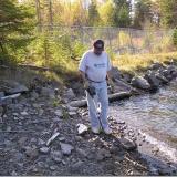 Using the metal detector to locate "treasures" at an old mine site. The fencing that you see in the background is to protect against falling into an open hole. Many of the very rich silver veins were exposed on surface and mined out completely. (Author: Joseph D'Oliveira)