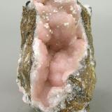 A specimen of Rhodochrosite with very few Kentrolite and minor white crystals of probably Calcite or Aragonite. (Author: Jordi Fabre)