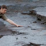 View of some of the dinosaur track ways in situ. The siltstone is at about 30 degrees to the horizontal. My comrade is for scale. (Author: vic rzonca)