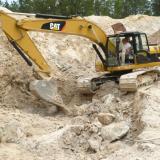 Track hoe, very useful for moving waste rock and for breaking up the granite. (Author: John S. White)