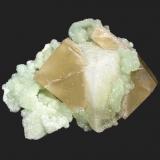 Prehnite and calcite
Weldon Quarry, Watchung, Somerset County, New Jersey
8.2 x 6.5 cm
A prehnite coated calcite rhombohedron with prehnite after glauberite epimorphs, sandwiched by a 6 cm second generation calcite crystal (Author: Frank Imbriacco)