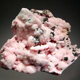 Rhodochrosite
Cavnic, Maramures, Romania
7.7 x 9.5 cm.
Rhodocrosite replacing platy calcite crystals with small metallic black tetrahedrite crystals on a matrix of massive white calcite and tetrahedrite. (Author: crosstimber)