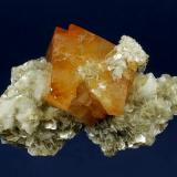 Scheelite on Muscovite
Mt. Xuebaoding, Pingwu County, Mianyang Prefecture, Sichuan Province, China
101 x 68 x 40 mm

Fiery-orange Scheelite measuring 55 x 43 mm is perched a sculptural matrix of Muscovite, accented by small gemmy Qyartz crystals.  Several nice rosettes of Muscovite are perched atop the Scheelite.  Absolutely pristine. (Author: GneissWare)