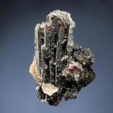 Hematite ps. ilvaite
Nikolaevskiy Mine, Dal’negorsk, Primorskiy Kray, Russia
3.5 x 6.5 cm
Elongated prismatic crystals of ilvaite have been partially replaced by hematite and dusted with a sparkly druse of micro quartz. Collected in 2005. (Author: crosstimber)