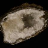 Mordenite
Sgurr nam Boc, Isle of Skye, Scotland, UK
10 cm x 5 cm x 6 cm deep

Mordenite in delicate crystals to 10mm long with a few stilbite crystals, in a quartz-lined cavity in basalt. This zeolite mineral is very silica-rich and to my knowledge is only found at this locality (on Skye, that is), where quartz is plentiful.
Self-collected 1998. (Author: Mike Wood)