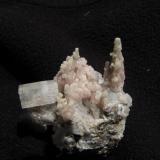 Thomsonite + Apophyllite
Moonen Bay, Isle of Skye, Scotland, UK
33mm x 30mm x 24mm
Pink coloured thomsonite in delicate stalactitic growths; quite unusual but rather pretty. The one on the right is 14mm tall. Associated with pinacoidal terminated apophyllite crystals.
Self-collected 2005 (Author: Mike Wood)