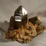 Smoky Quartz + Albite
Lundy Island, Devon, England, UK
80mm x 55mm x 65mm high (specimen)
Nicely terminated smoky quartz crystal 40mm tall on pegmatite matrix. Collected 1998. (Author: Mike Wood)