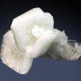 Apophyllite-(KF)
Mahodari Quarry, Nasik District, Maharashtra, India
4.5 x 7.0 cm.
A small group of milky-white, tabular crystals to 3 cm with pale green cores and truncated corners. Collected from a single pocket in 1999. (Author: crosstimber)