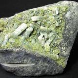 Escapolita, epidota y pumpellita
Archidona, Málaga, Andalucía, España
6 x 6 cm.
Cristales blancos de escapolita y granos verdes de epidota, todo recubierto por una fina vellosidad de pumpellita, en una grieta muy rica en cristales de las ofitas de Archidona.  El color real es un verde algo más intenso que el que aparece en la fotografía. (Autor: prcantos)