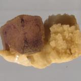 Fluorite on Albite
Lundy Island, Devon, England, UK
Specimen 20mm across
Purple fluorite crystal (8 x 8 x 6mm) on albite (var. cleavelandite). The fluorite ’cube’ has corner modifications. (Author: Mike Wood)
