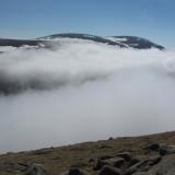 A little over an hour later I was back in the sunshine on the other side of the valley. The mountain in the distance is Ben Macdui, which I traversed the day before in a fruitless search for phenakite. (Author: Mike Wood)