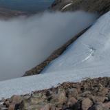 I had to carefully negotiate the huge snowdrift to begin the descent. A slip here would have been diastrous and I only had a hiking stick - should have had an ice-axe really. Fortunately the snow was slightly soft. If it had been rock-hard neve I wouldn’t have attempted it. (Author: Mike Wood)