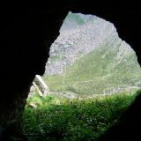 View looking out of the cave to the other side of the valley, where the &rsquo;Shelter Stone &rsquo; lies - it is a huge flat boulder which climbers and bivouac enthusiasts have &rsquo;camped&rsquo; beneath, since climbing started around here.

For my next trick, from the so-called crystal cave I decided to take a short-cut to the top of the cliff via a likely looking gully around the corner. Not one of my better ideas - I seemed to have forgotten that gullies usually become steeper and steeper the higher up you go! Carrying a large heavy rucksack and wearing big boots I found myself astride between rock walls in the steepest part of the gully (which was about 70 degrees) and wishing I wasn&rsquo;t there! But I was committed and knew that the only way to do it was to focus my mind and go for it, which I did. Fortunately the difficulties were short, the angle eased off, and I was mighty relieved to top out on the nice flat grassy plateau, for a not very well-deserved rest!!
 Lesson learned?? Not really, just part of the experience, but I&rsquo;ll certainly remember it, which is the main thing.   -_- (Author: Mike Wood)