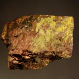 Autunite
Ruggles Mine, Grafton, Grafton Co., New Hampshire, USA
5.1 x 7.5 cm
Bright yellow crusts and lustrous platy micro-crystals of autunite on brownish feldspar with minor black uraninite. (Author: crosstimber)