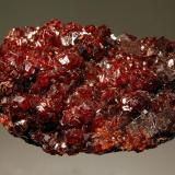 Andradite
N&rsquo;Chwaning II Mine, Kuruman, N. Cape Prov., South Africa
4.2 x 5.6 cm
A flat plate of dark red andradite crystals to 0.8 cm covering a mixture of massive andradite with embedded metallic black hematite crystals to 2 mm. (Author: crosstimber)