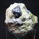 Hematites, lizardita, hidrotalcita
Dypingdal serpentine-magnesite deposit, Snarum, Modum, Buskerud, Noruega
4 x 4 cm.
Un octaedro de hematites en una roca ultrabásica serpentinizada y afectada por metasomatismo (serpentina verde e hidrotalcita blanca).  De hecho, el octaedro era una antigua magnetita pseudomorfizada por la actual hematites. (Autor: prcantos)