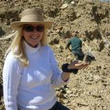 Ronna Jewett, discoverer of the mondo best pocket holding a small quartz from her find.  The pocket exceeded 4 feet (1.3 m) in depth by the time it was finished. (Author: Tony L. Potucek)