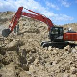 Foster Hallman, former owner with over 4 decades of experience on Petersen Mt., running the Hitachi excavator. (Author: Tony L. Potucek)