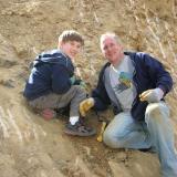 Portland, Oregon father-son collectors Jack (left) and Floyd (right) enjoying the dig.  Son Jack found a very clear amethyst scepter point in the pocket, undamaged, and the point of the scepter in the amethyst head could clearly be seen.  Floyd is one of the owners of Jackson Crossroads in Georgia. (Author: Tony L. Potucek)