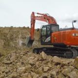 Foster is a genius with the trackhoe.  He not only scrapes the walls of the pits, he also removes a lot of the rock rubble at the foot of the walls and he opens access to the walls so that it is easy to walk up to them. (Author: John S. White)