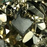 Beryl (variety emerald), Calcite and Pyrite<br />Chivor mining district, El Acuario Mine, Municipio Chivor, Eastern Emerald Belt, Boyacá Department, Colombia<br />Dolomite rhomb ~1cm<br /> (Author: Fiebre Verde)