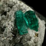 Beryl (variety emerald), Calcite, Pyrite<br />Chivor mining district, El Oriente Mine, Municipio Chivor, Eastern Emerald Belt, Boyacá Department, Colombia<br />Crystal on the left is 14mm long.<br /> (Author: Fiebre Verde)