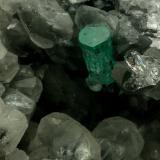 Beryl (variety emerald), Calcite, QuartzLa Pita (distrito minero), Municipio Maripí, Cinturón Esmeraldífero Occidental, Departamento Boyacá, ColombiaEmerald crystal is 11mm long (Author: Fiebre Verde)
